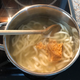 Added udon noodles into dashi and stirring in miso paste